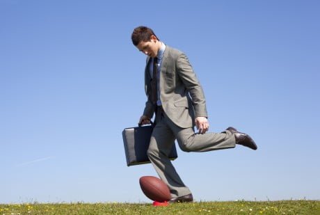 businessman kicking a football