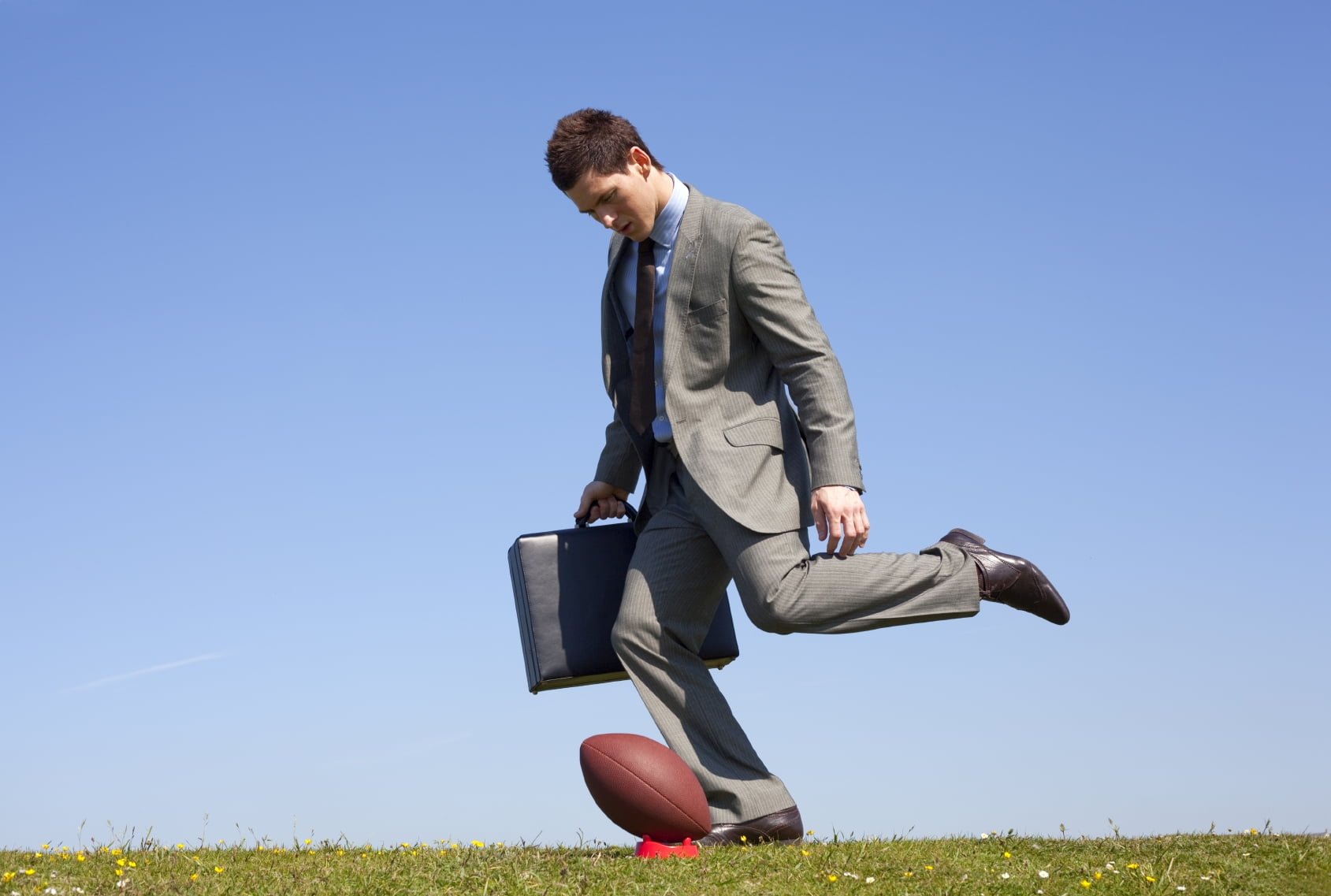 businessman kicking a football