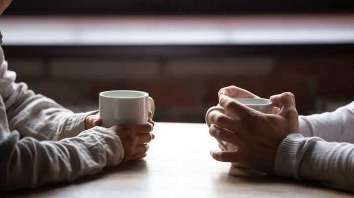 two people each holding a mug