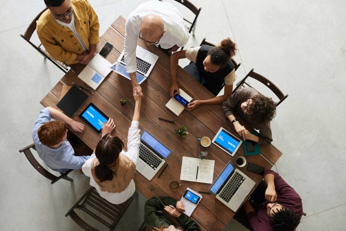 people-sitting-around-table-with-laptops