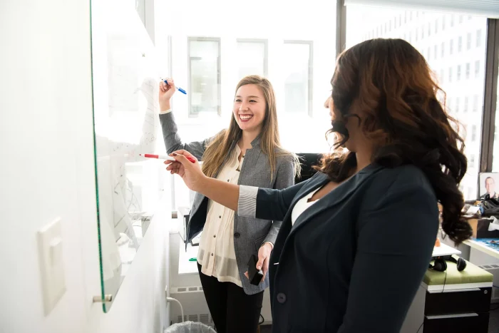 two-women-writing-on-a-whiteboard